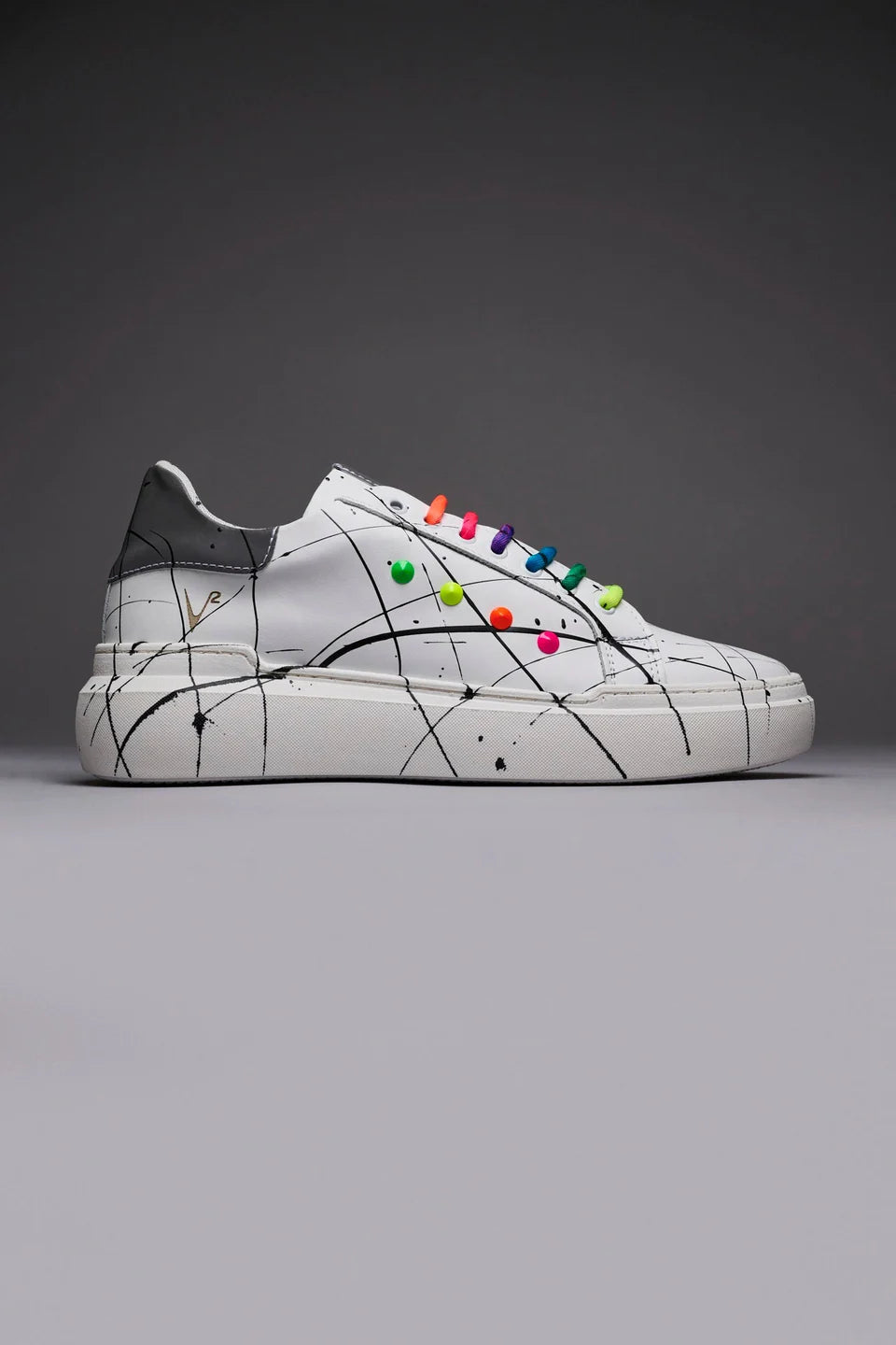 Vega - Sneakers a suola alta bianca retro catarifrangente con lacci e borchie multicolor e schizzi di vernice