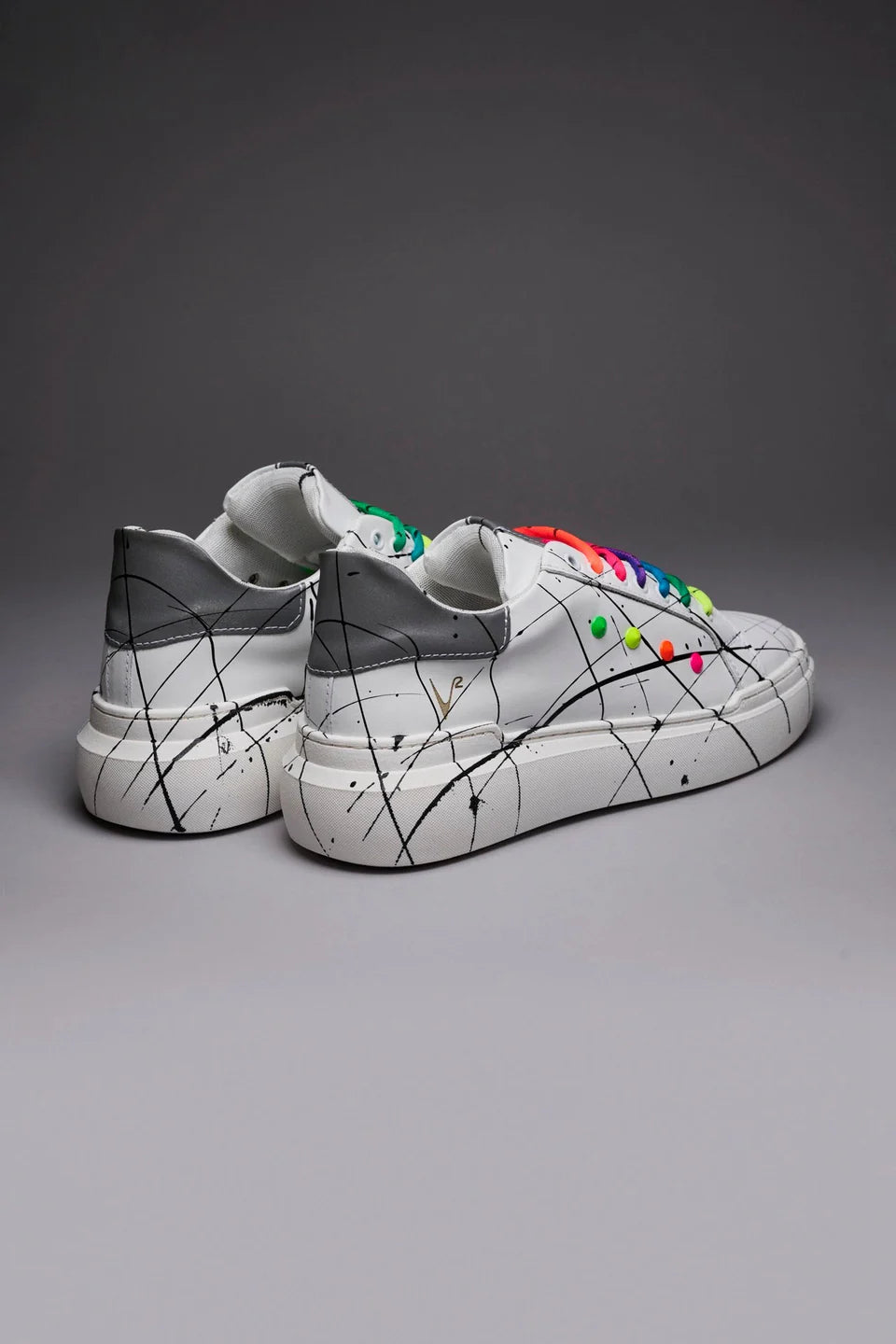 Vega - Sneakers a suola alta bianca retro catarifrangente con lacci e borchie multicolor e schizzi di vernice